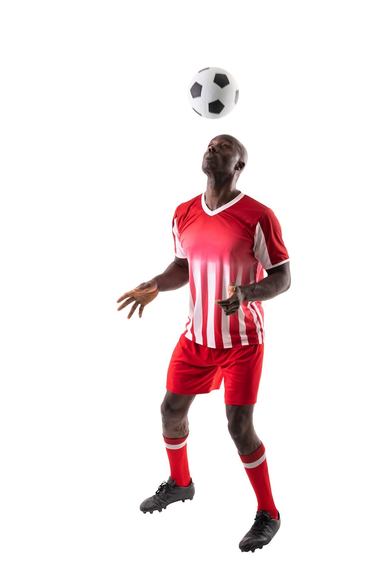 Photo un jeune footballeur afro-américain qualifié dirige le ballon sur un fond blanc.