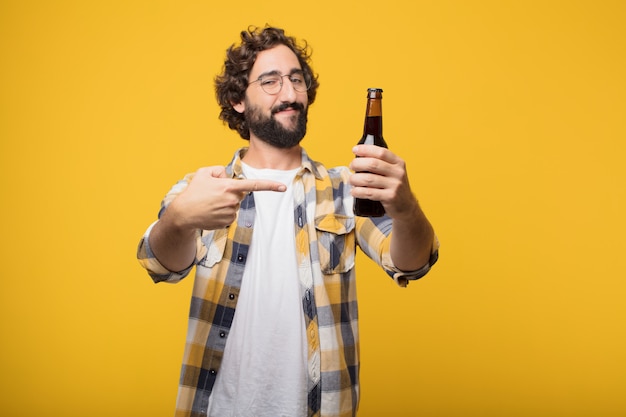 Jeune fou fou fou pose avec une bouteille de bière.