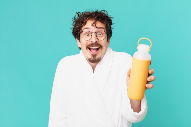 Jeune fou avec un thermo de café