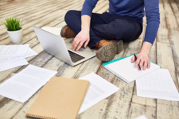 Jeune Freelancer travaillant sur le plancher