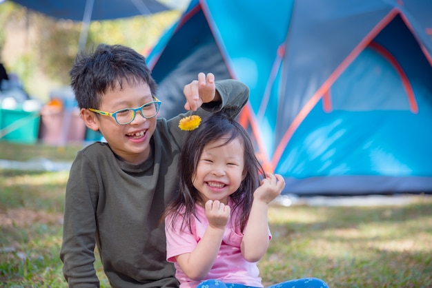 Jeune frère asiatique et soeur jouant ensemble au camping