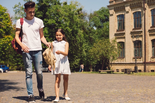 Photo jeune frère et sœur heureux pendant la marche