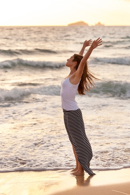 Jeune, gai, femme, étirage, pieds nus, bord mer