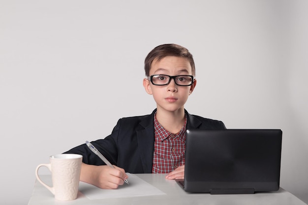 Jeune garçon d'affaires en costume et lunettes