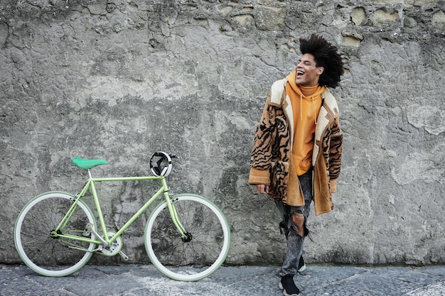 Photo jeune garçon africain s'amusant avec son vélo en plein air dans la ville - focus on face