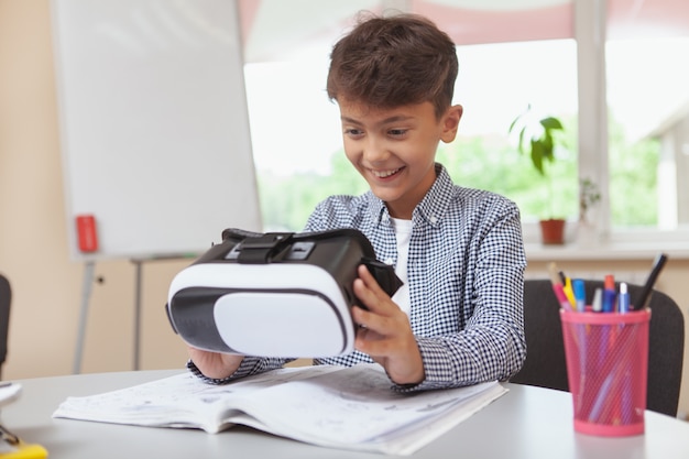 Jeune garçon à l'aide d'un casque de réalité virtuelle 3d à l'école