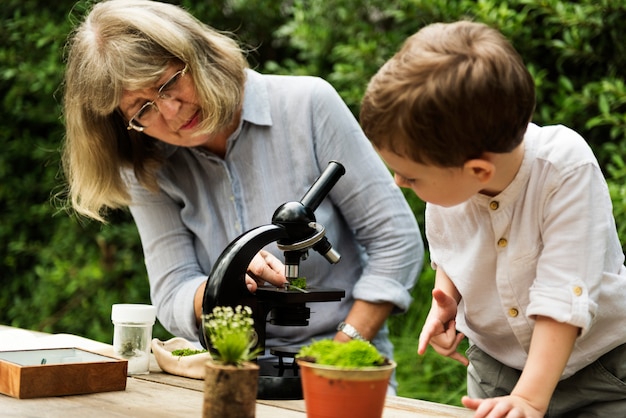 Jeune garçon apprenant avec une vieille femme et un télescope