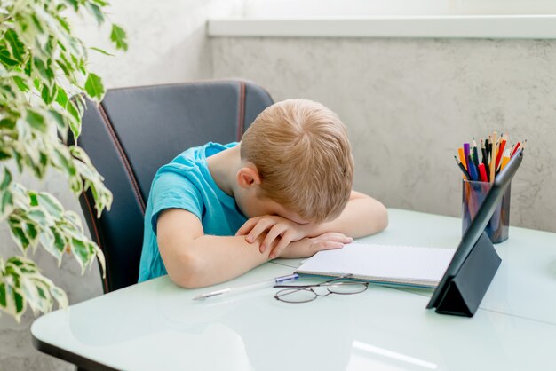 Jeune garçon apprend par tablette à la maison. Enseignement à distance en quarantaine.