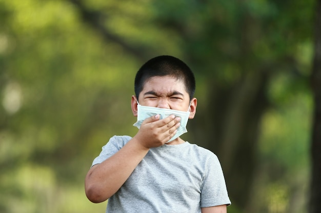 jeune garçon asiatique, porter un masque pour se protéger de la poussière PM 2,5 et des germes