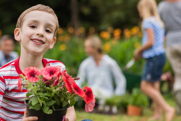 Jeune garçon assis avec pot de fleur