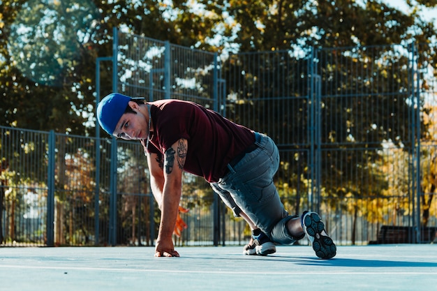 Jeune garçon b dansant et posant au terrain de basket