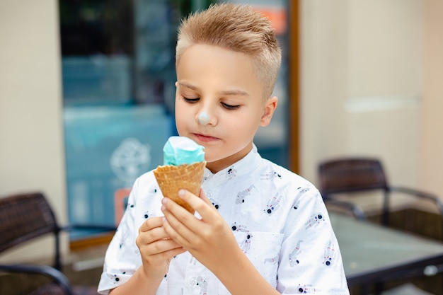 Jeune garçon blond avec de la glace dans ses mains