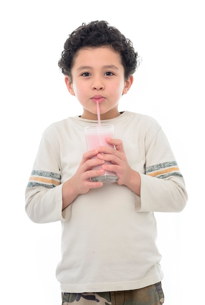 Jeune garçon buvant du lait frappé aux fraises