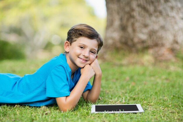 Jeune garçon, coucher herbe, à, tablette numérique