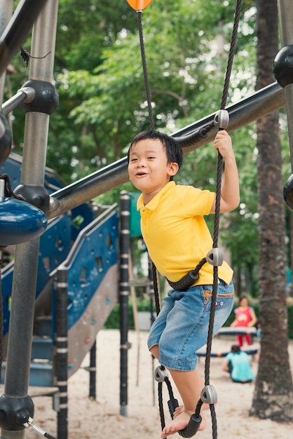 Jeune garçon dans le parc d'escalade