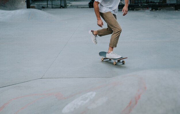 Jeune garçon effectuant des tours avec la planche à roulettes dans un skate park