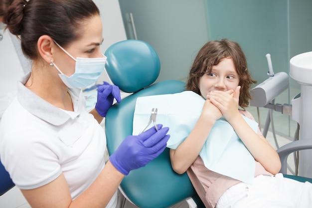 Jeune garçon effrayé refusant d'ouvrir la bouche pour un examen dentaire à la clinique