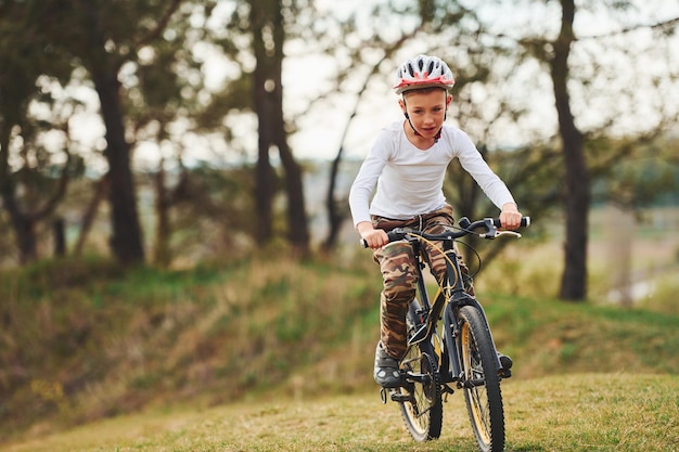 Jeune garçon faisant du vélo à l'extérieur dans la forêt pendant la journée