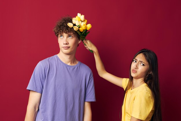 Jeune garçon et fille bouquet de fleurs cadeau romance fond isolé inchangé