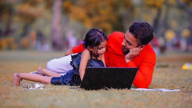 Jeune garçon et jolie fille enfant ayant un ordinateur portable d'origine indienne étudiant