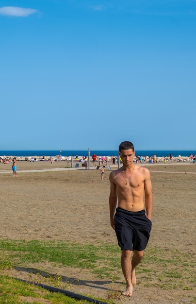Jeune garçon marchant vers la caméra sur la plage de Malagueta à Malaga Espagne