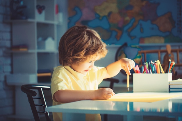 Jeune garçon peignant le lettrage décoratif avec la peinture de couleur de stylo