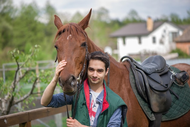 Jeune garçon pendant la marche de montage élevée rencontre un jeune cheval et communique avec lui la nature sauvage les gens et les animaux amitié concept style de vie été en plein air