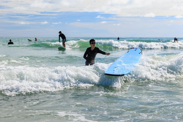 Photo un jeune garçon portant avec impatience un maillot de bain et des lunettes pratique le surf