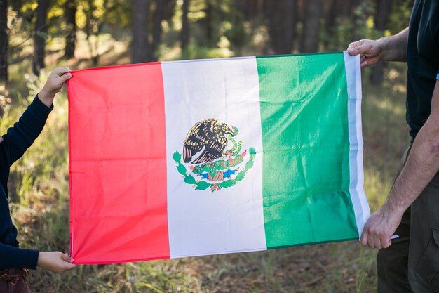 Jeune garçon avec son père tenant le drapeau mexicain