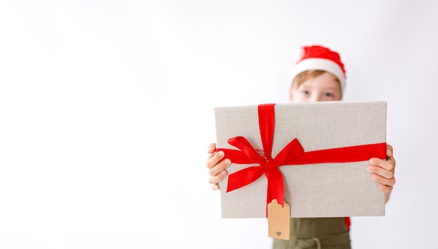 Le jeune garçon sourit avec son cadeau de Noël