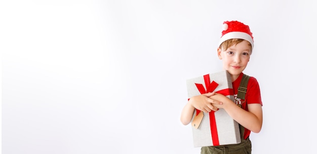 Le jeune garçon sourit avec son cadeau de Noël