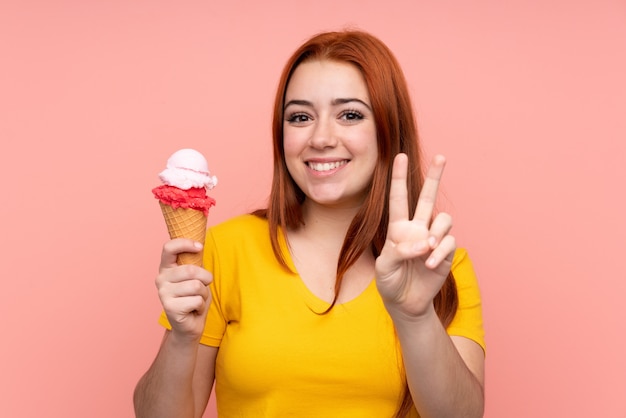 Jeune, girl, cornet, glace, isolé, mur, Sourire, projection, victoire, signe