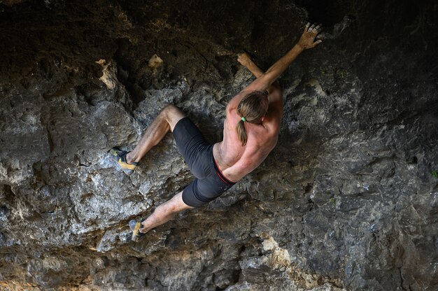 Jeune Grimpeur Mâle Bouldering Une Paroi Rocheuse Dans Une Grotte