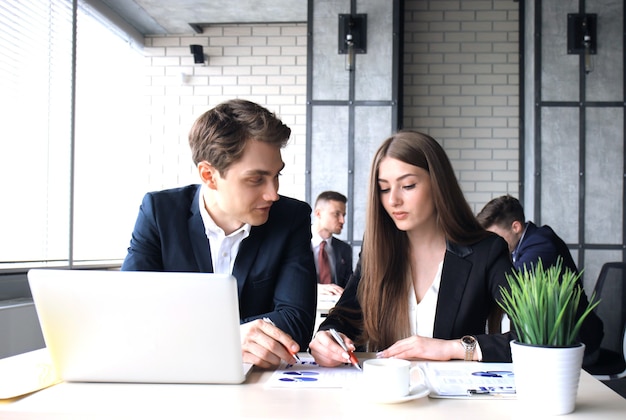 Jeune groupe de personnes faisant leur travail sur ordinateur portable.