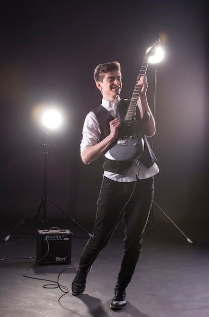 Jeune guitariste à la guitare électrique sur dark