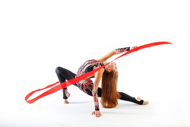 Jeune gymnaste féminine avec ruban rouge sur fond blanc