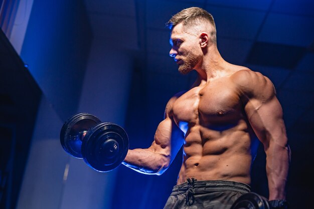 Jeune haltérophile bodybuilder sportif beau avec un corps idéal