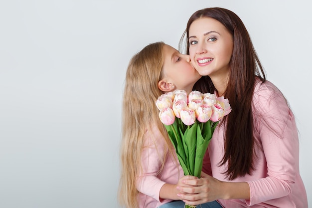 Jeune heureuse mère et fille avec bouquet de tulipes