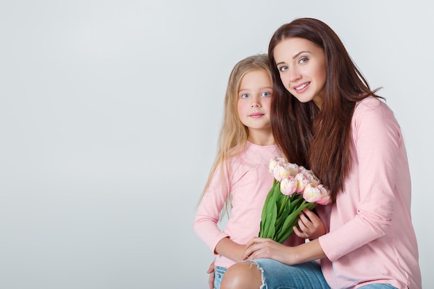 Jeune heureuse mère et fille avec bouquet de tulipes