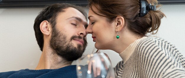 Photo jeune et heureux couple buvant du vin et se relaxant à la maison