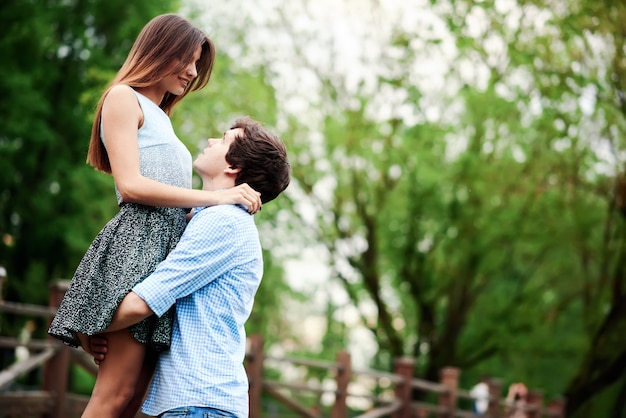 Jeune et heureux couple embrassant dans le parc d'été de la ville