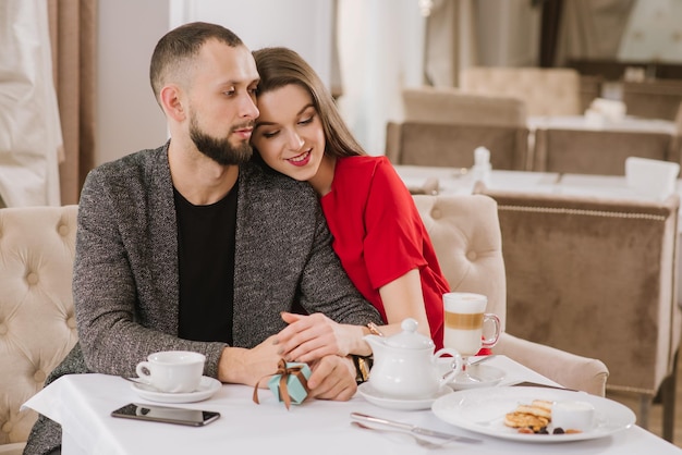 Jeune et heureux couple parlant et s'amusant au restaurant