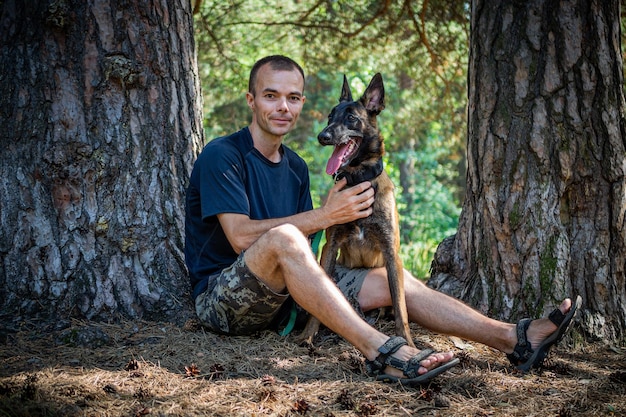 Jeune hipster caucasien passe du temps avec son chien dans le parc par une journée d'été ensoleillée Le concept d'un animal de compagnie en tant que membre de la famille