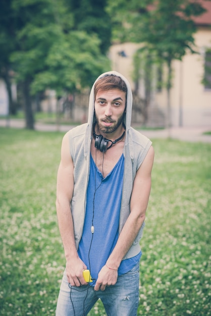 jeune hipster gay man écoutant de la musique casque