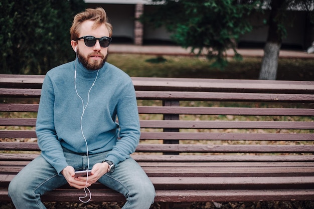 jeune hipster gay man écoutant de la musique casque