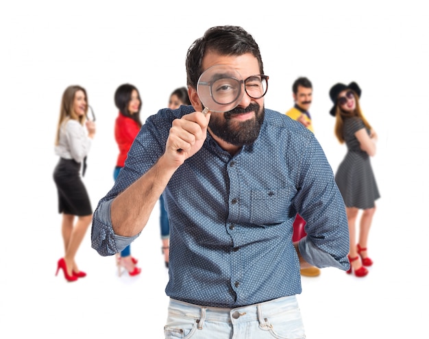 Jeune hipster homme avec loupe