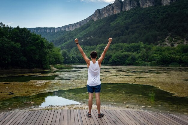 Le jeune hipster mâle regardant la belle vue sur le lac