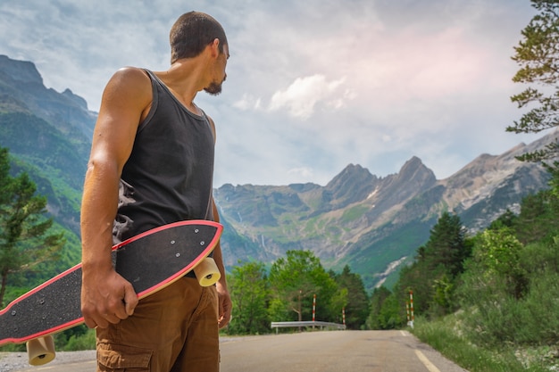 Jeune hipster tenant un longboard cool à la main