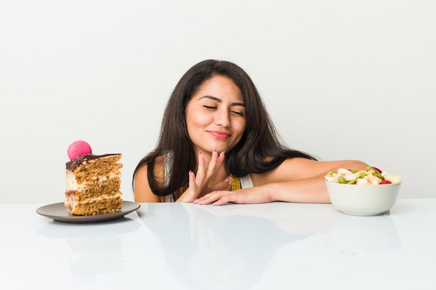 Jeune, hispanique, femme, choisir, gâteau, fruit, bol