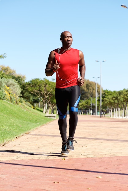 Jeune homme actif avec un casque jogging en plein air